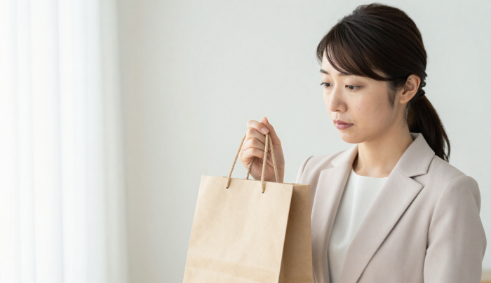 手土産の紙袋を前に悩んでいるイメージ